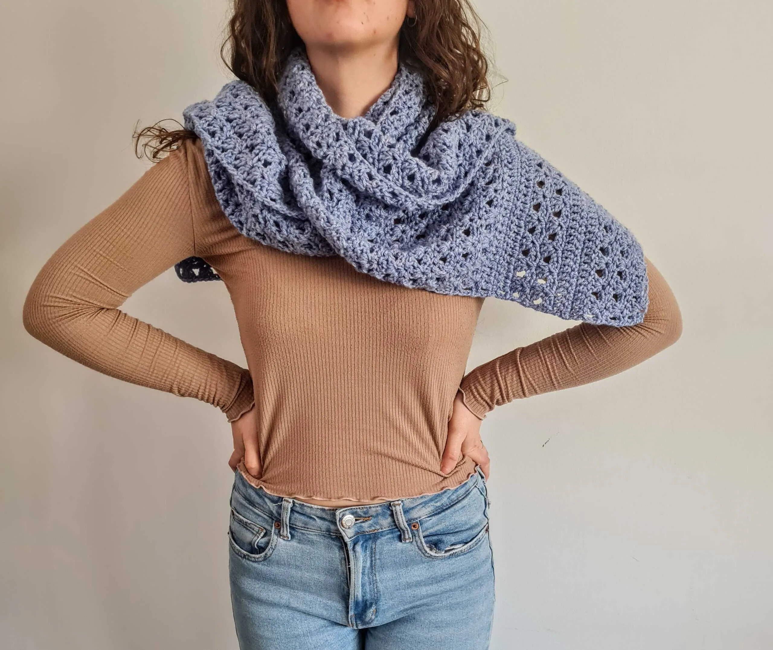 Wide blue textured crochet Sky Scarf draped over shoulders showing the cluster and V stitch pattern