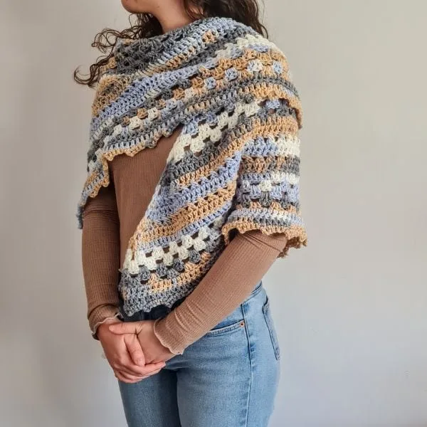 Finished triangle crochet shawl in blue, green, and beige variegated yarn, the Nordic Trails design