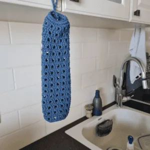 Crochet plastic bag holder in cotton hanging by the sink