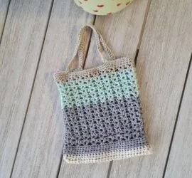 Finished crochet mesh market bag stretched to hold fresh produce showing the open V stitch weave