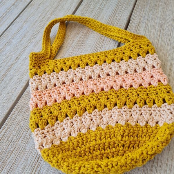 Close-up of a striped crochet tote bag with sturdy handles, made using an easy free crochet tote bag pattern.