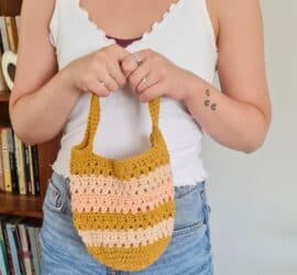 Close-up of a striped crochet tote bag with sturdy handles, made using an easy free crochet tote bag pattern.