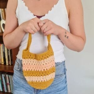 Close-up of a striped crochet tote bag with sturdy handles, made using an easy free crochet tote bag pattern.