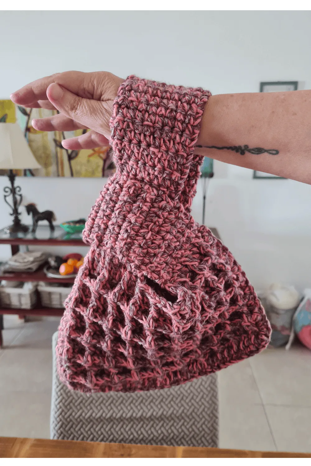 Crochet waffle stitch Japanese knot wrist bag in dusty rose variegated yarn held on wrist showing texture and handle shape