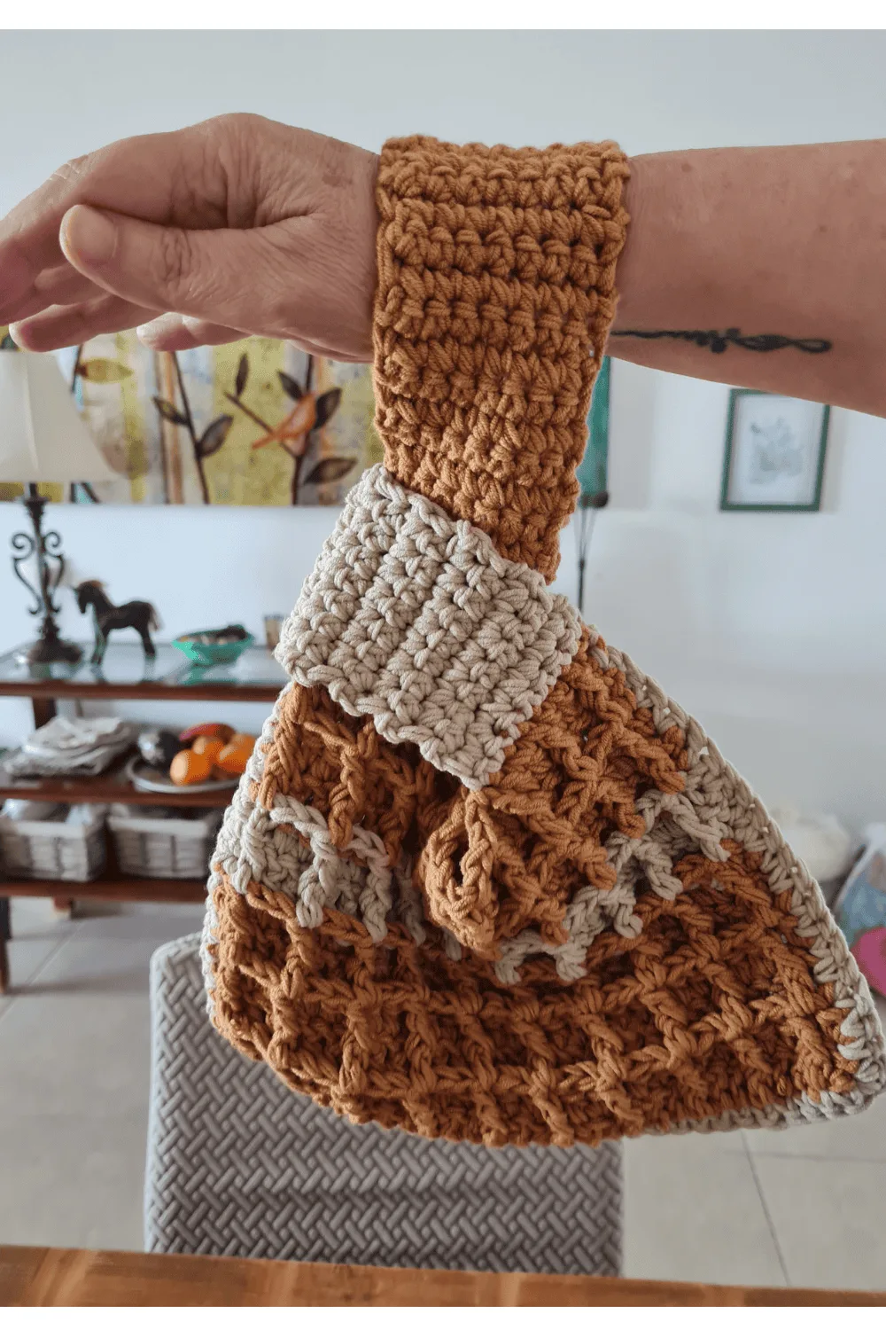 Crochet waffle stitch Japanese knot wrist bag in dusty rose variegated yarn held on wrist showing texture and handle shape