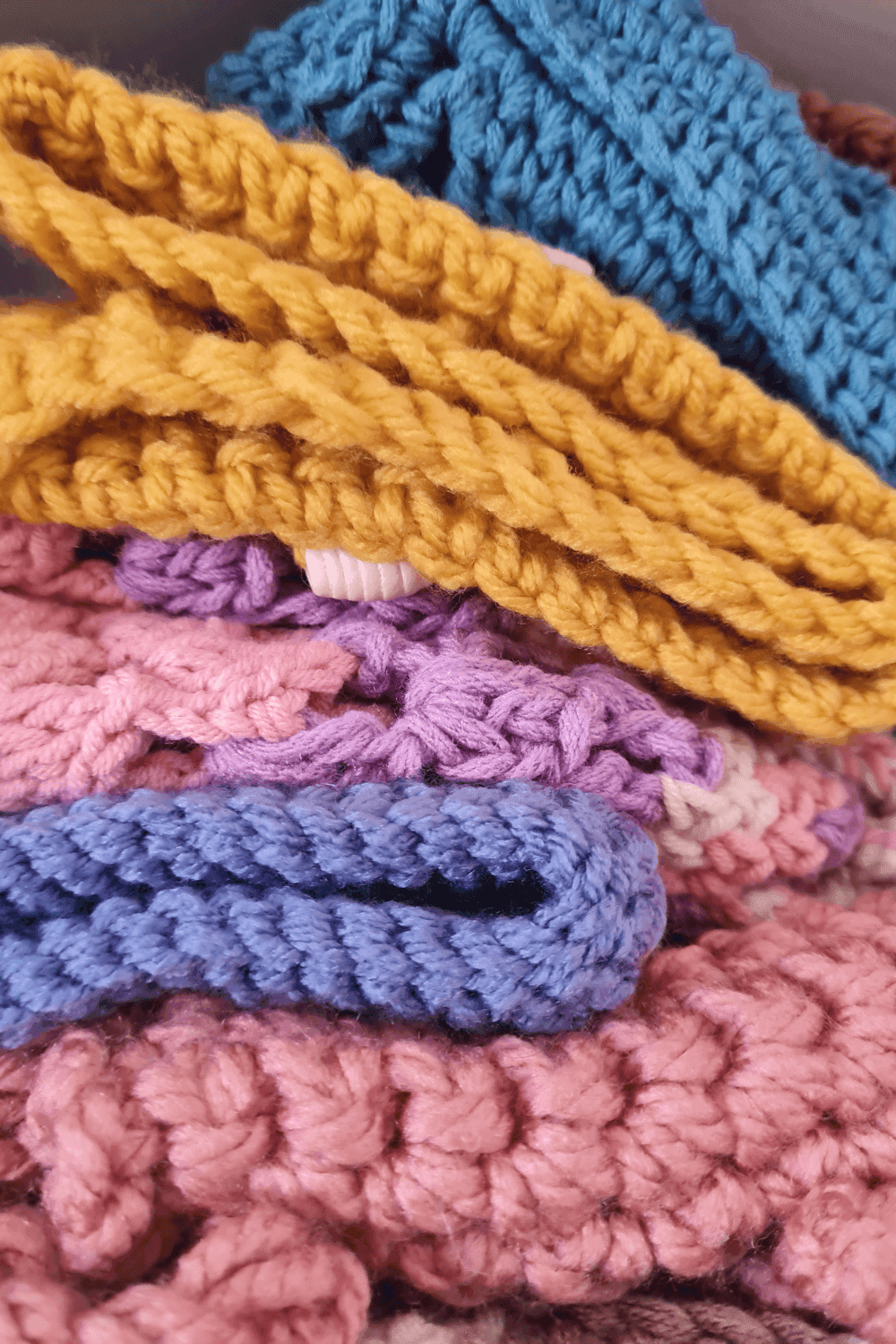 Brightly colored crocheted scarves with textured stitches, perfect for winter warmth and stylish acces.