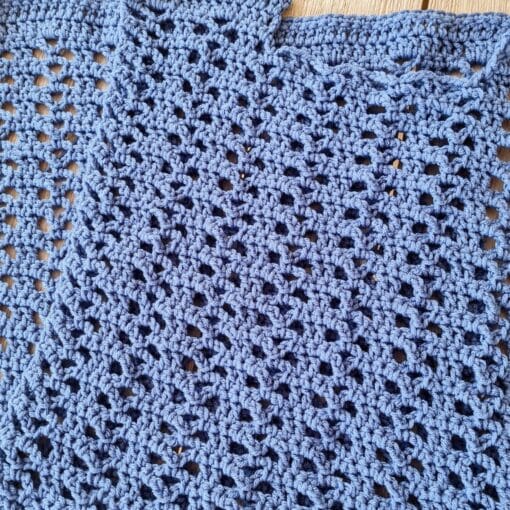 Two identical crochet rectangle panels in blue laid flat before seaming