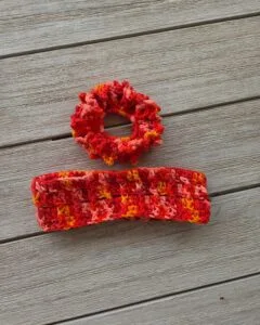 Small crochet envelope bag made from three granny squares folded into triangles in variegated pink and orange yarn