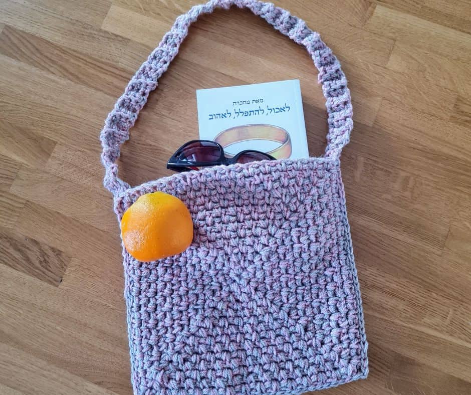 Pink and beige crochet bag with a long strap, made from two strands of yarn held together