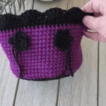 Purple and black crochet basket with black flower,