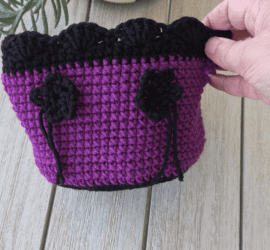 Purple and black crochet basket with black flower,
