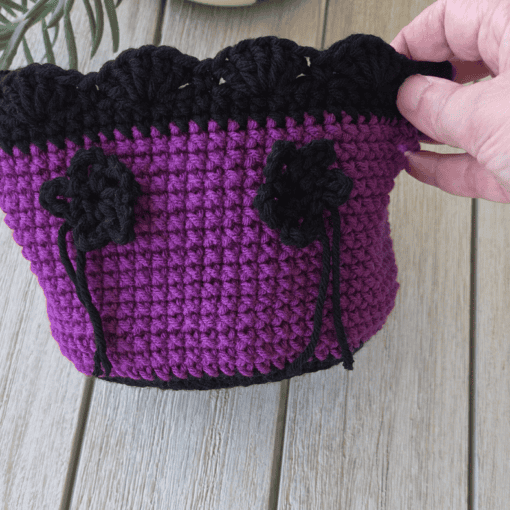 Purple and black crochet basket with black flower,