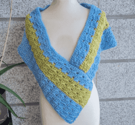 Finished crochet poncho wrap styled on mannequin, closed wrap version