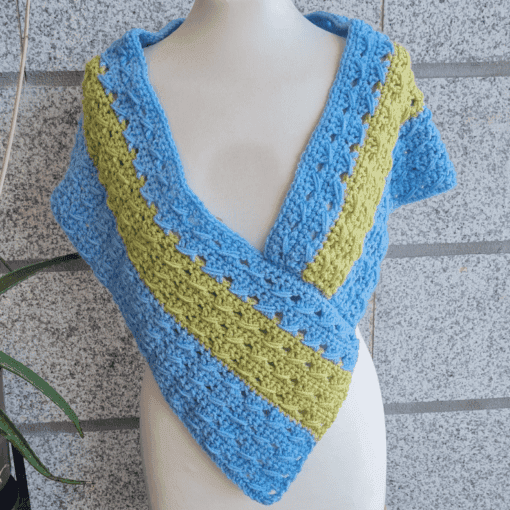 Finished crochet poncho wrap styled on mannequin, closed wrap version
