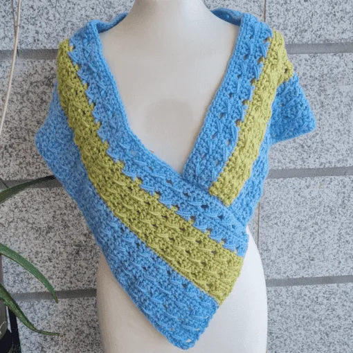 Finished crochet poncho wrap styled on mannequin, closed wrap version