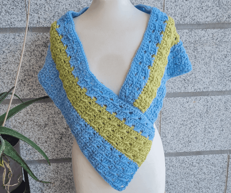 Finished crochet poncho wrap styled on mannequin, closed wrap version